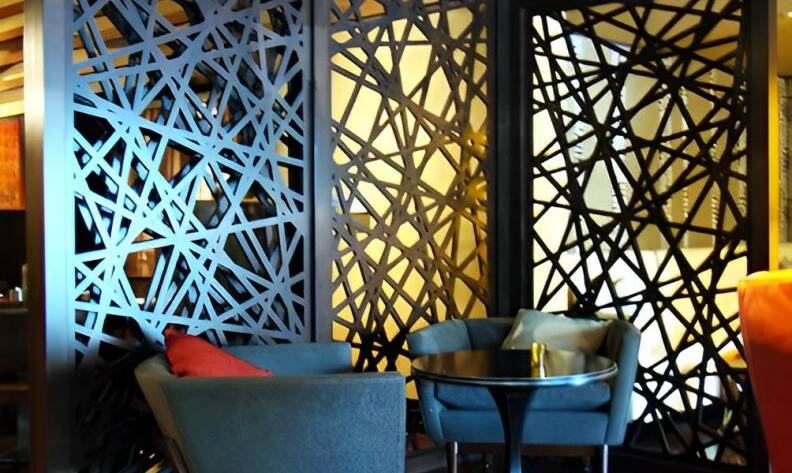 Geometric pattern design on wooden panels separating tables in a restaurant