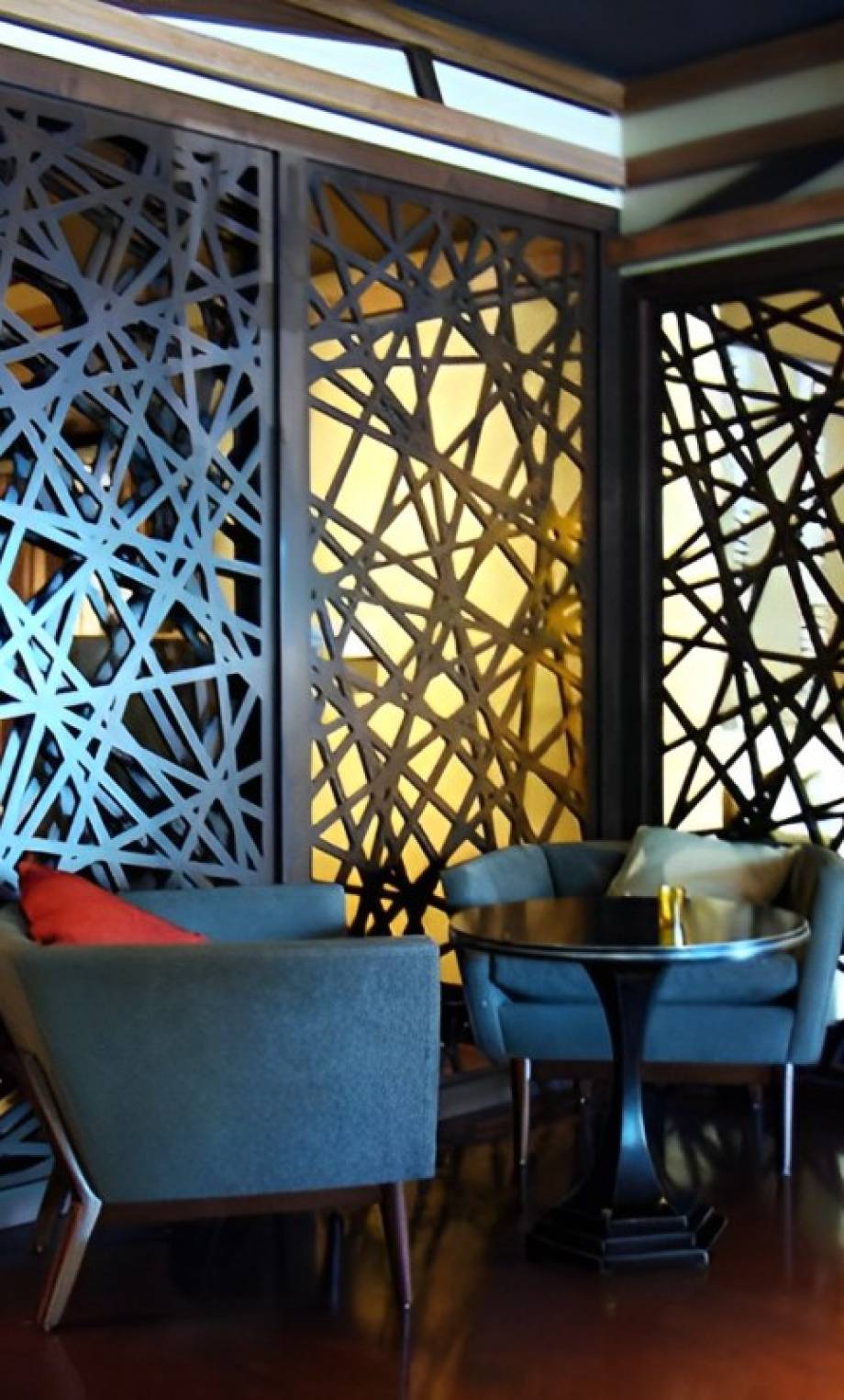 Geometric pattern design on wooden panels separating tables in a restaurant